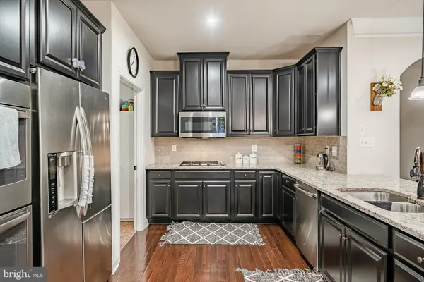 a kitchen with counter space appliances and living room view