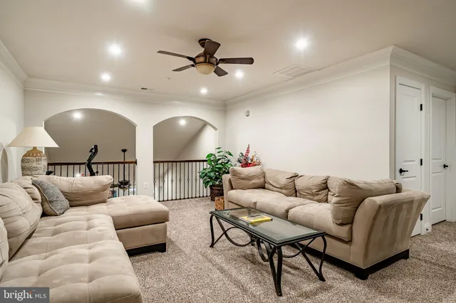 a living room with furniture and a ceiling fan