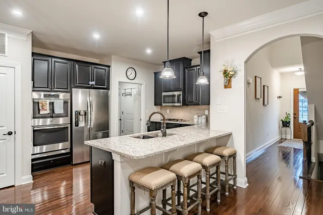 a kitchen with stainless steel appliances granite countertop a sink a stove and refrigerator