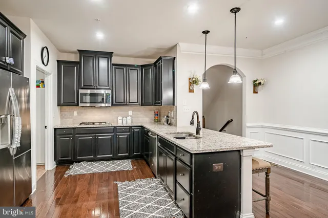 a kitchen with stainless steel appliances granite countertop a refrigerator and a sink