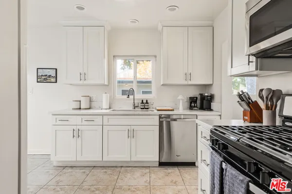 a kitchen with cabinets appliances and a window