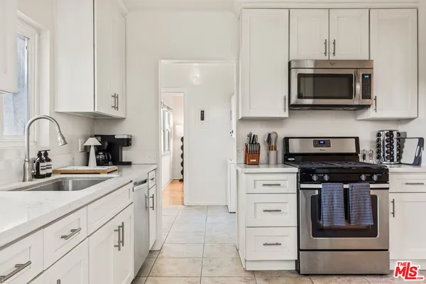 a kitchen with cabinets stainless steel appliances and sink