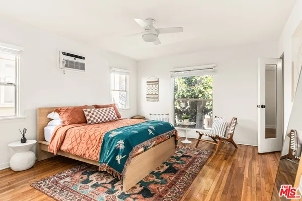 a bedroom with a bed lamp and a potted plant