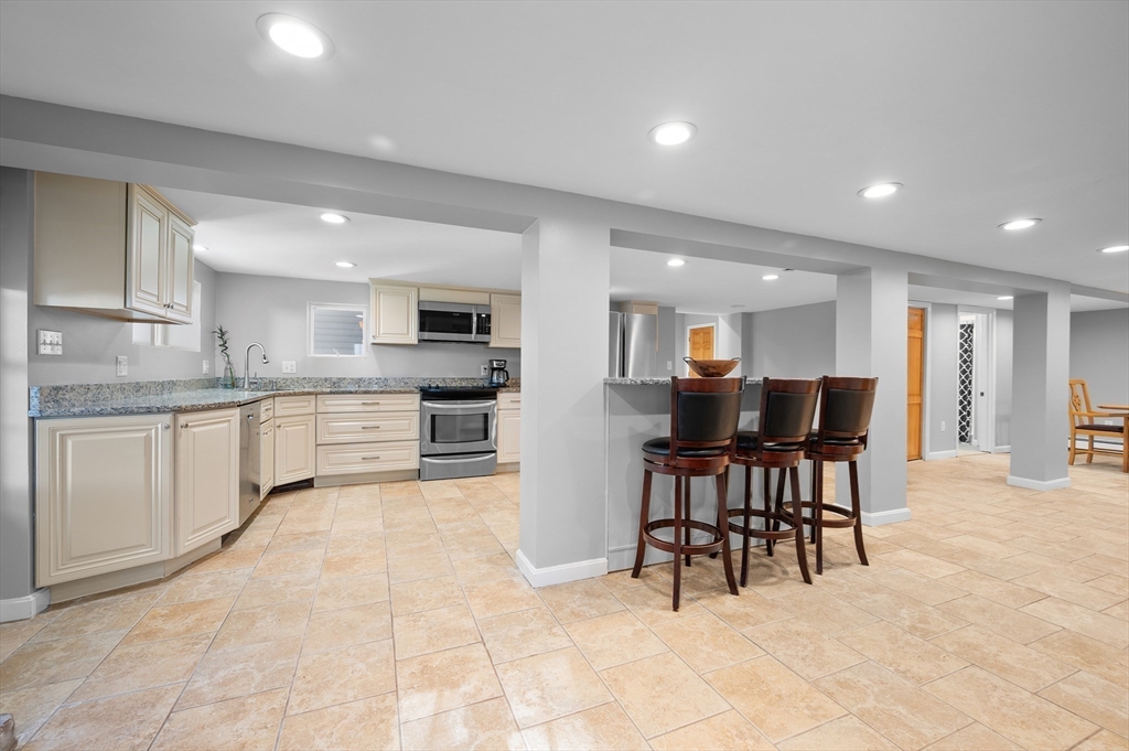 27 Downey Street Hopkinton, MA 01748 - Photo 7 of 36 a view of kitchen with kitchen island a dining table chairs and white cabinets