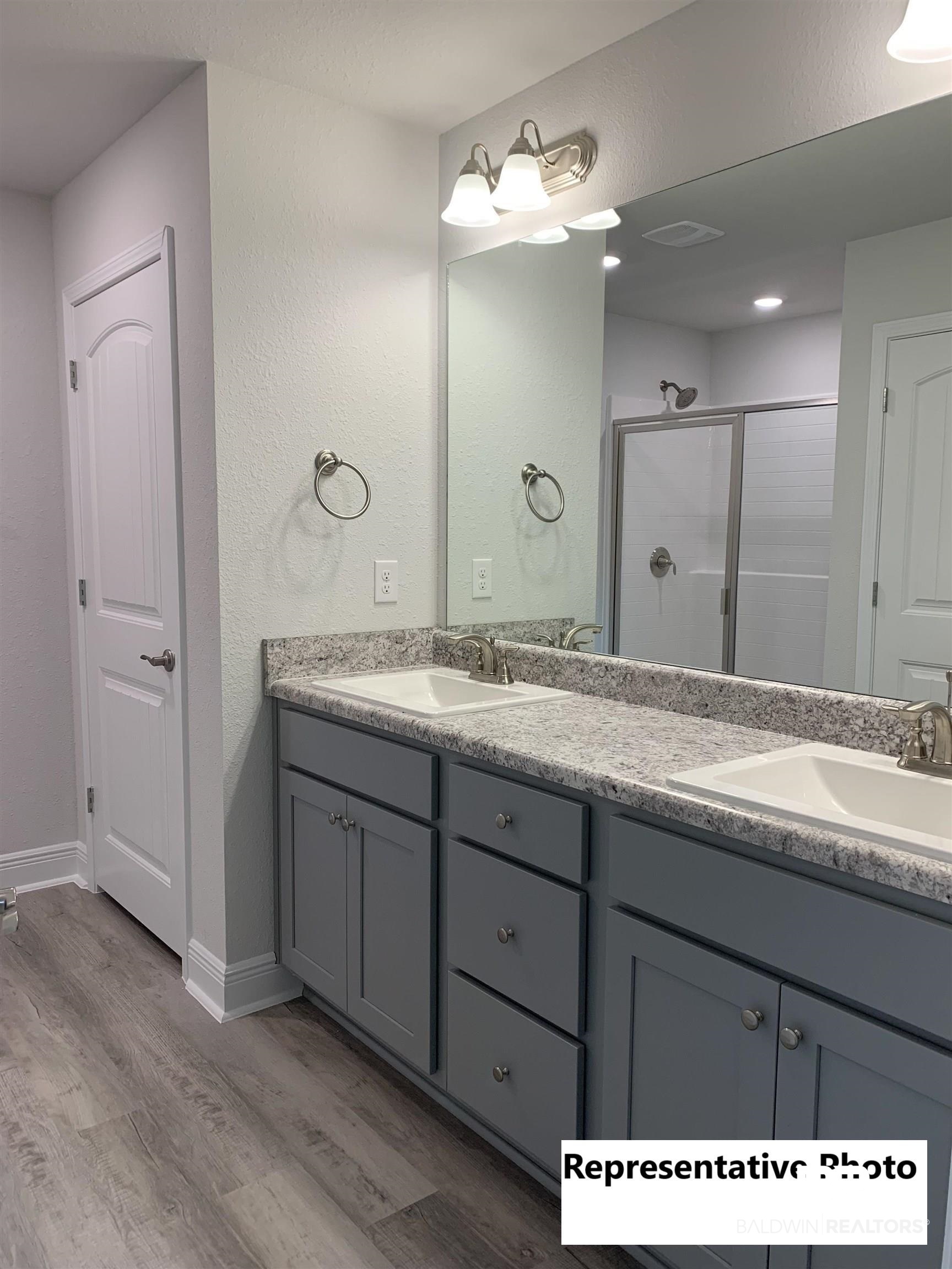 645 Revere Street Foley, AL 36535 - Photo 11 of 14 Bathroom featuring hardwood / wood-style flooring, walk in shower, and vanity