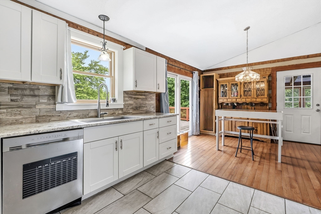 22 Lyon Hill Road Chester, MA 01011 - Photo 15 of 38 a open kitchen with granite countertop a stove a sink and white cabinets with wooden floors