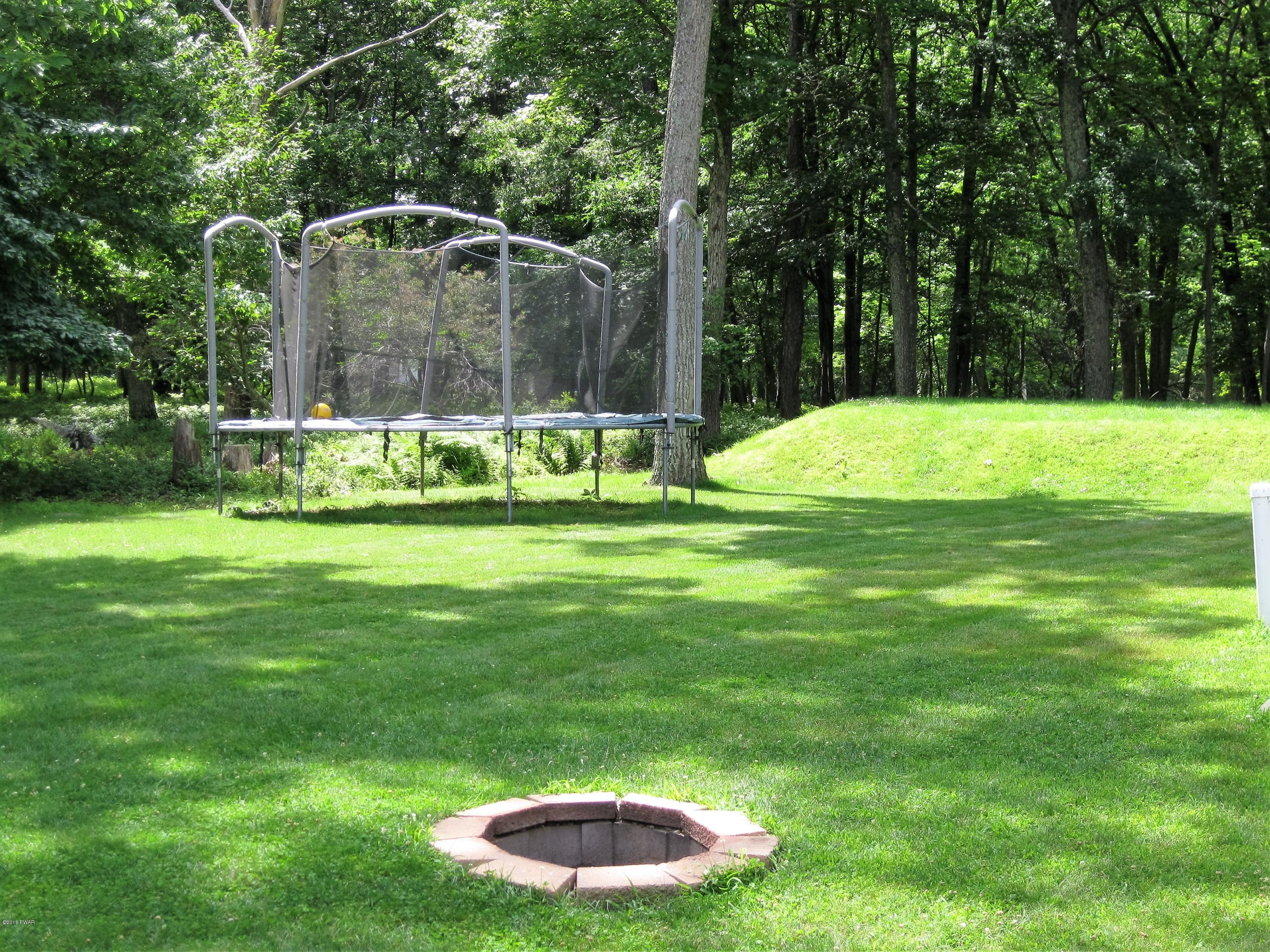 137 Caribou Road Dingmans Ferry, PA 18328 - Photo 29 of 34 a backyard of a house with swimming pool and green space