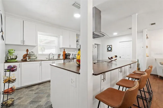 a kitchen with granite countertop lots of white cabinets and stainless steel appliances