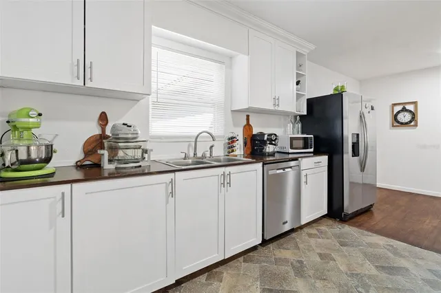 a kitchen with white cabinets and refrigerator