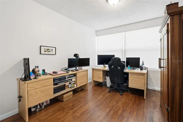 a view of a workspace with furniture and a window