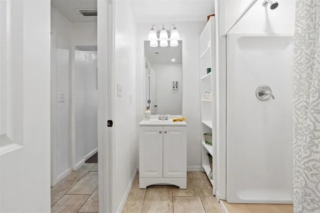 a bathroom with a granite countertop shower a sink and a mirror