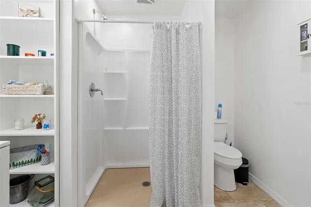 a bathroom with a toilet and a shower curtain
