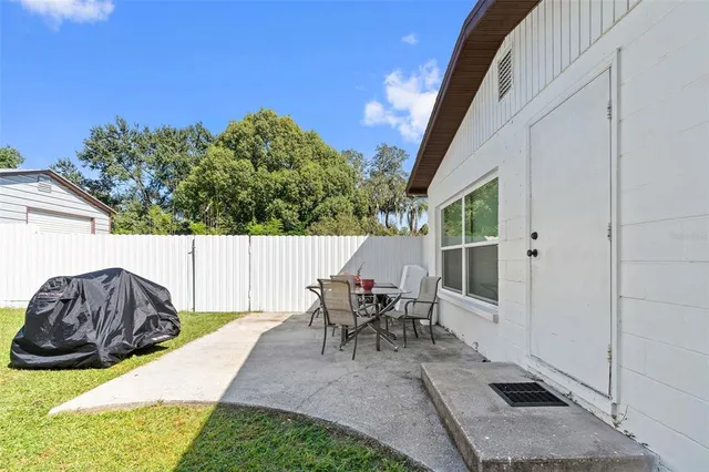 a backyard of a house with table and chairs