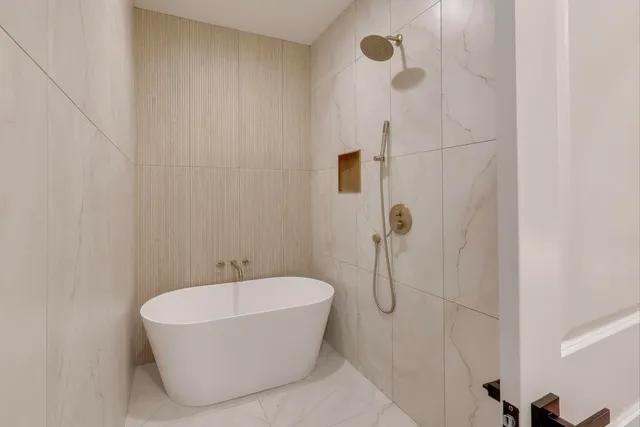 a bathroom with a white bath tub and shower