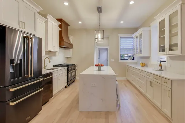 a large kitchen with stainless steel appliances lots of counter space and a sink