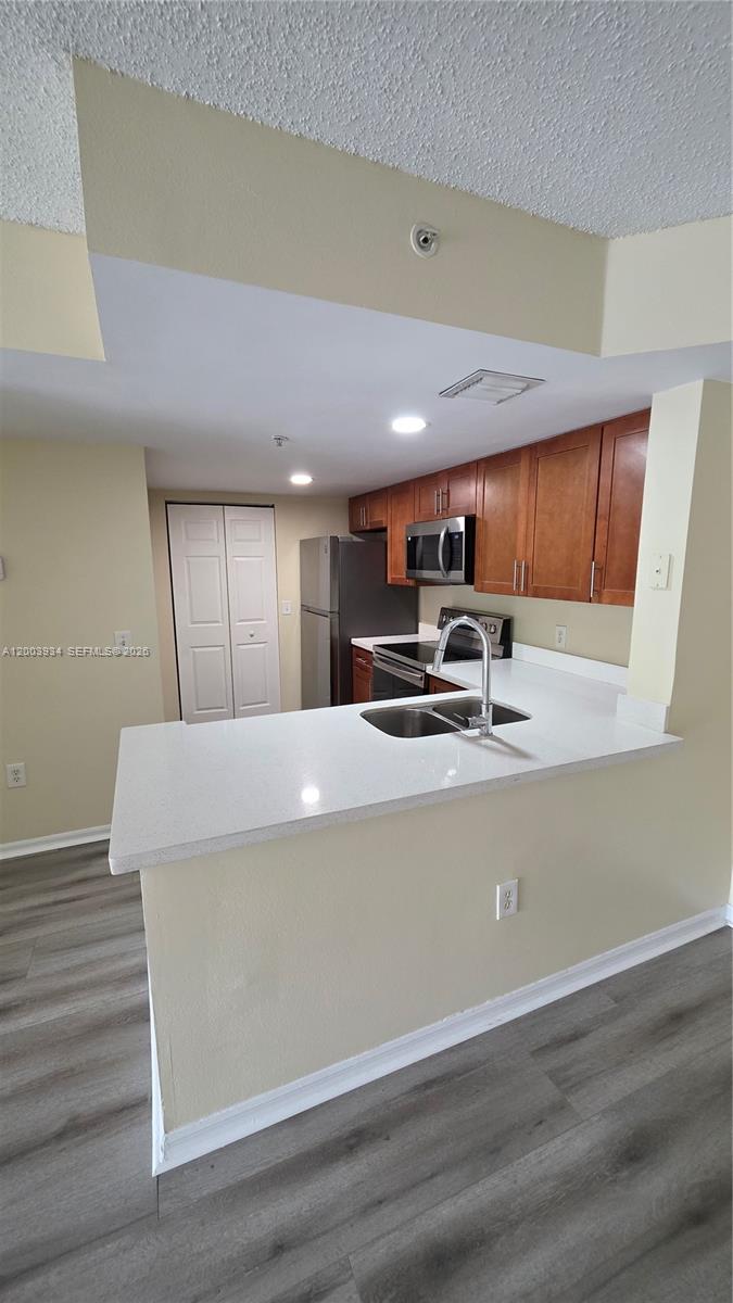 a view of kitchen with stainless steel appliances granite countertop refrigerator sink and stove