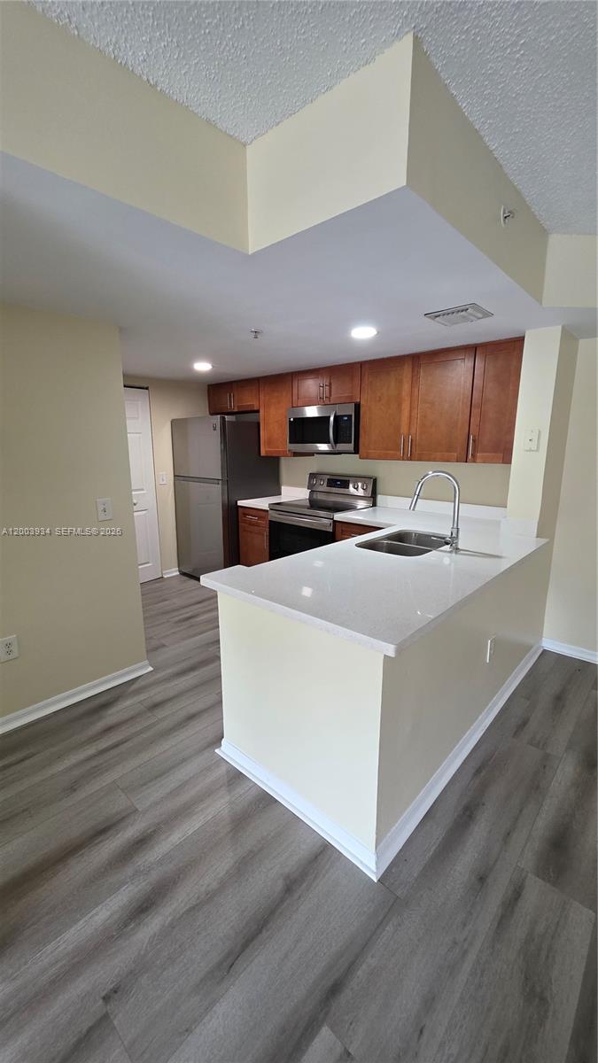 5051 Wiles Road, Unit 201 Coconut Creek, FL 33073 - Photo 13 of 43 a kitchen with stainless steel appliances a stove a sink and a refrigerator