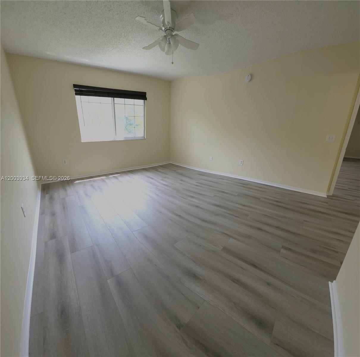 5051 Wiles Road, Unit 201 Coconut Creek, FL 33073 - Photo 18 of 43 an empty room with wooden floor and windows
