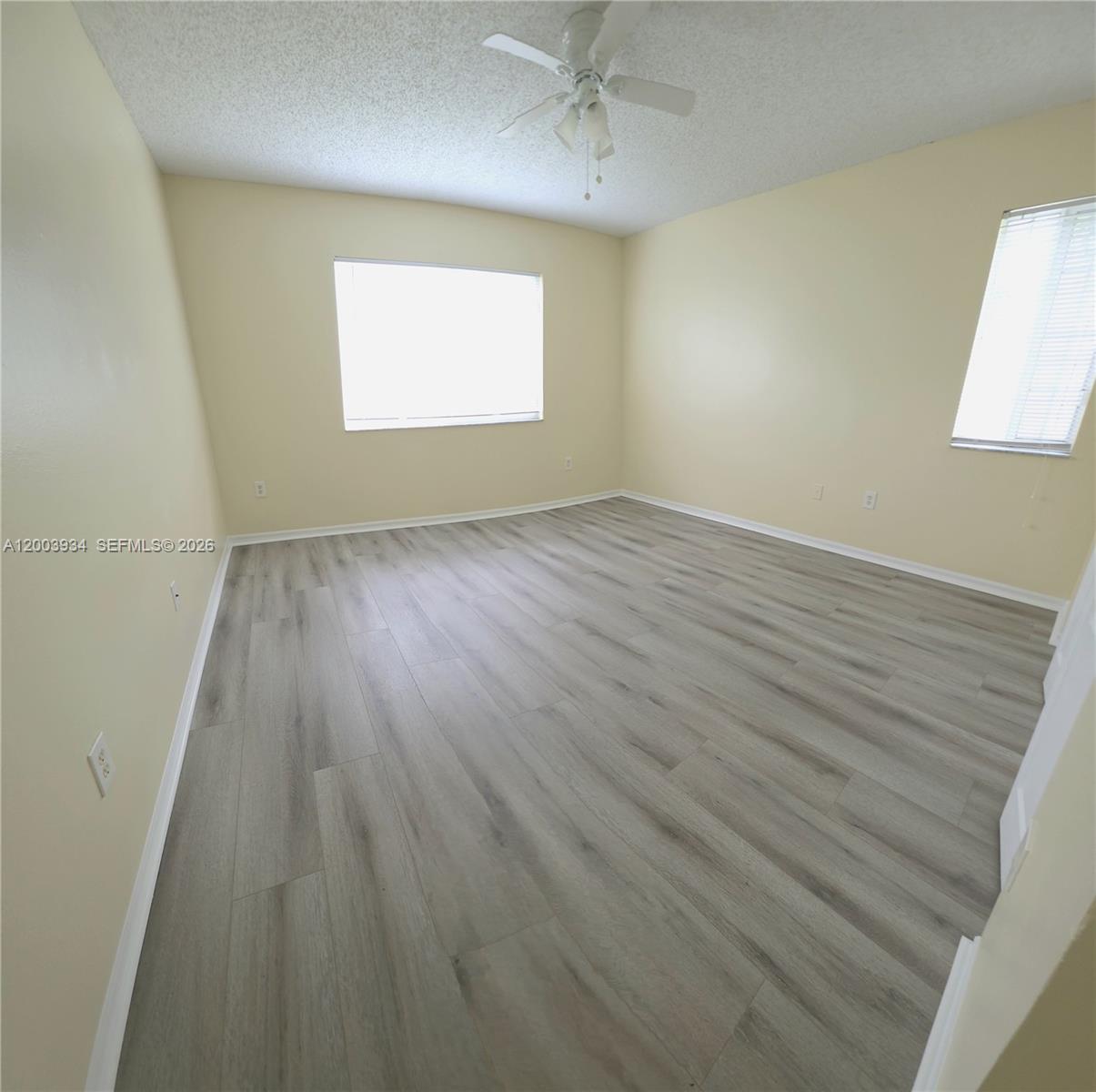5051 Wiles Road, Unit 201 Coconut Creek, FL 33073 - Photo 20 of 43 an empty room with wooden floor and windows
