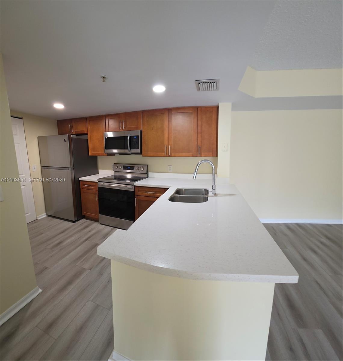 5051 Wiles Road, Unit 201 Coconut Creek, FL 33073 - Photo 2 of 43 a kitchen with stainless steel appliances a refrigerator and a stove top oven