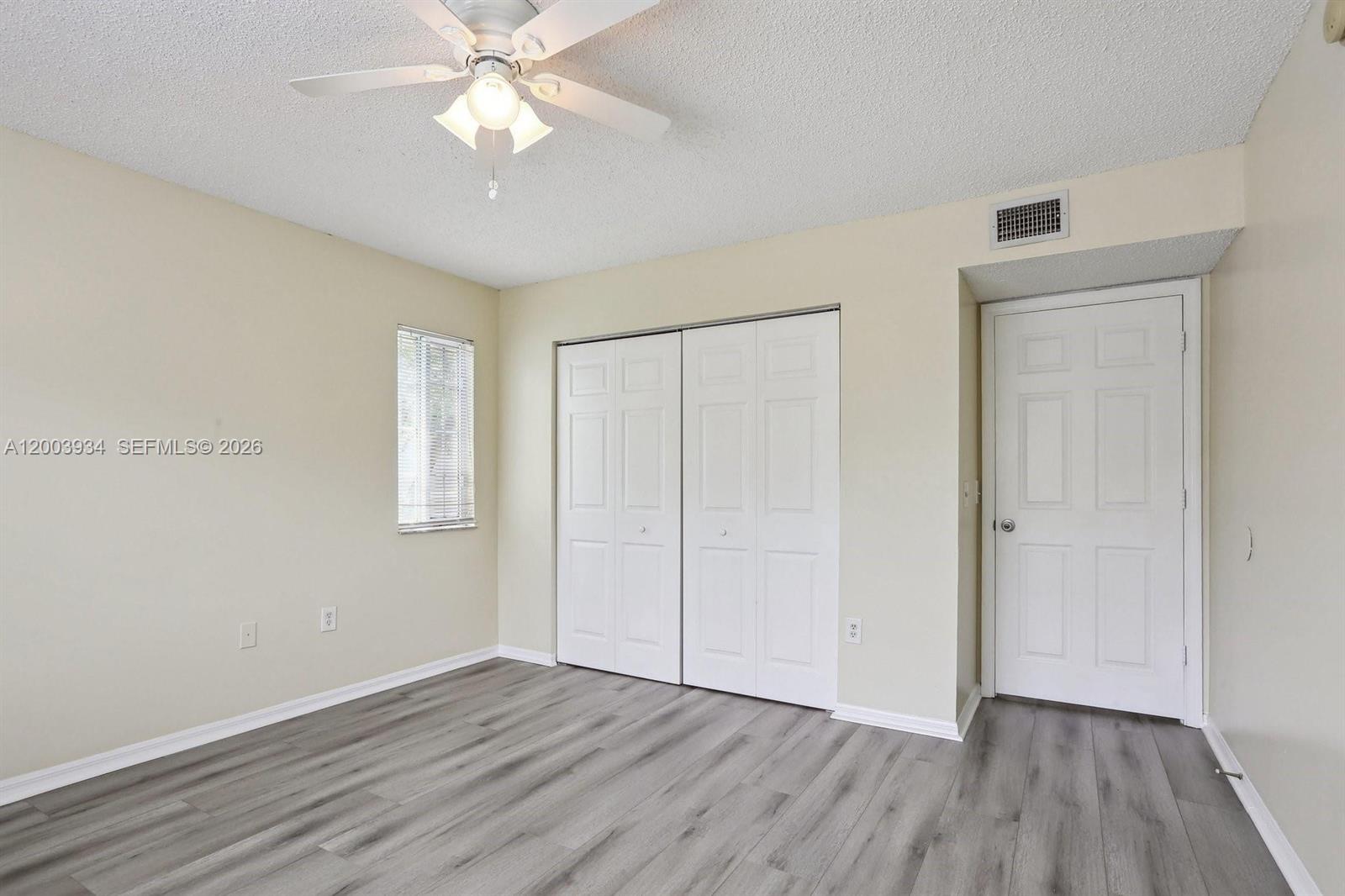 5051 Wiles Road, Unit 201 Coconut Creek, FL 33073 - Photo 26 of 43 wooden floor in an empty room with a window