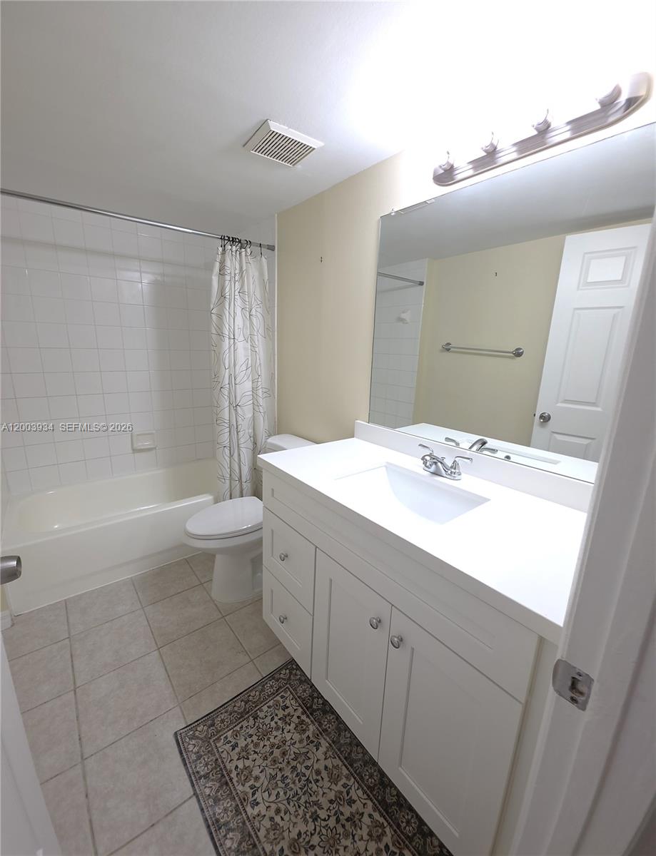 5051 Wiles Road, Unit 201 Coconut Creek, FL 33073 - Photo 27 of 43 a bathroom with a sink a toilet and shower