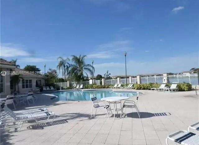 5051 Wiles Road, Unit 201 Coconut Creek, FL 33073 - Photo 37 of 43 a view of a swimming pool and outdoor seating