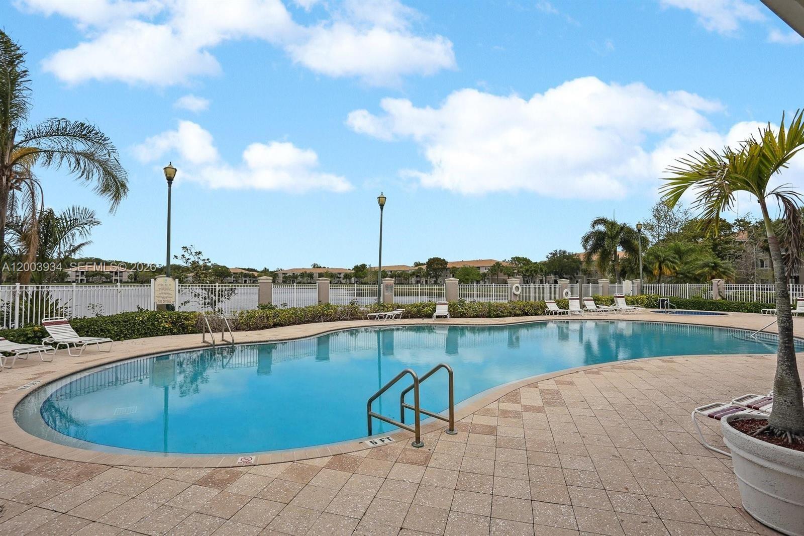 5051 Wiles Road, Unit 201 Coconut Creek, FL 33073 - Photo 38 of 43 a view of a swimming pool with a lounge chairs