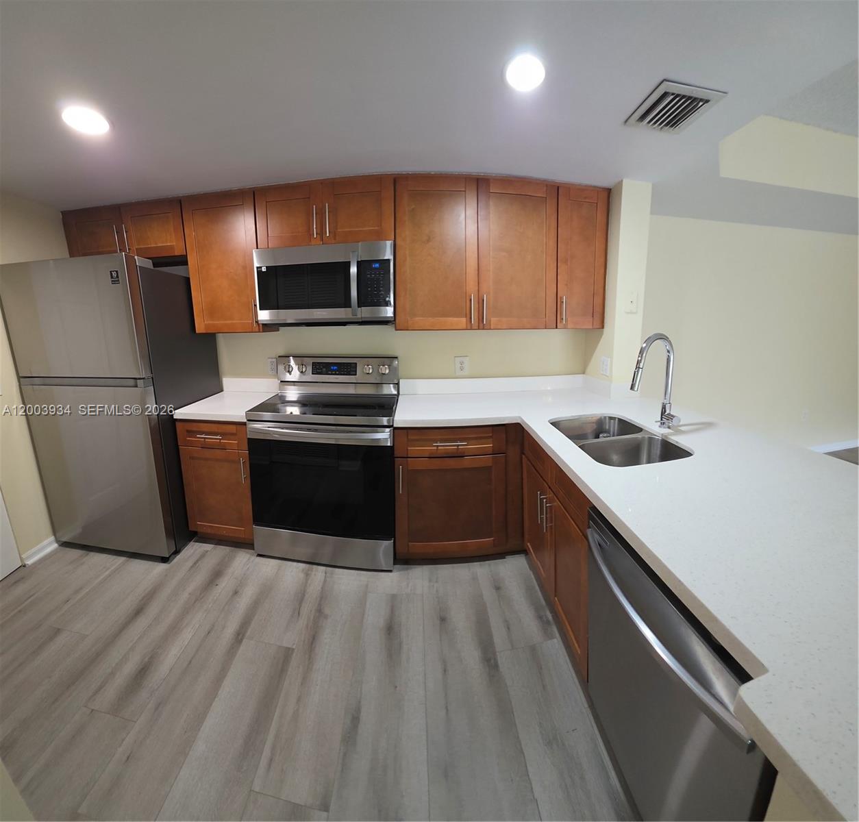 5051 Wiles Road, Unit 201 Coconut Creek, FL 33073 - Photo 4 of 43 a kitchen with sink a microwave and refrigerator