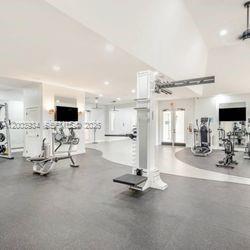 5051 Wiles Road, Unit 201 Coconut Creek, FL 33073 - Photo 42 of 43 a view of a room with gym equipment and flat screen tv