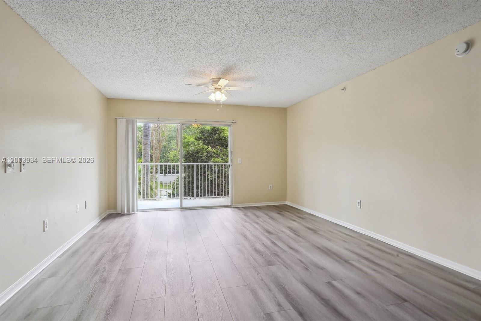 5051 Wiles Road, Unit 201 Coconut Creek, FL 33073 - Photo 5 of 43 wooden floor in an empty room with a window