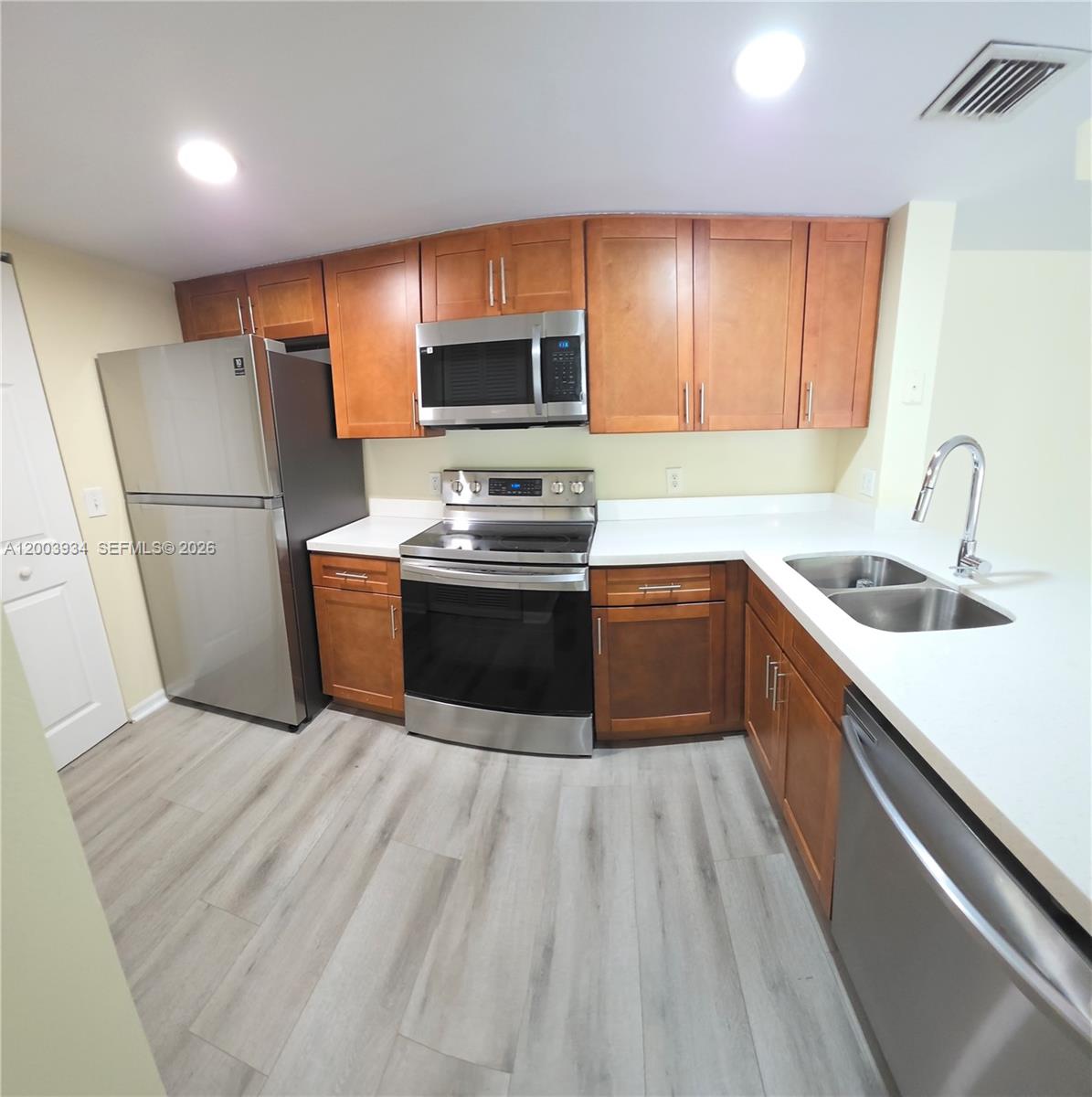 5051 Wiles Road, Unit 201 Coconut Creek, FL 33073 - Photo 7 of 43 a kitchen with stainless steel appliances a sink stove refrigerator and cabinets