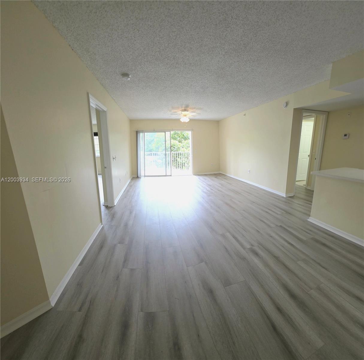 5051 Wiles Road, Unit 201 Coconut Creek, FL 33073 - Photo 8 of 43 an empty room with wooden floor and windows