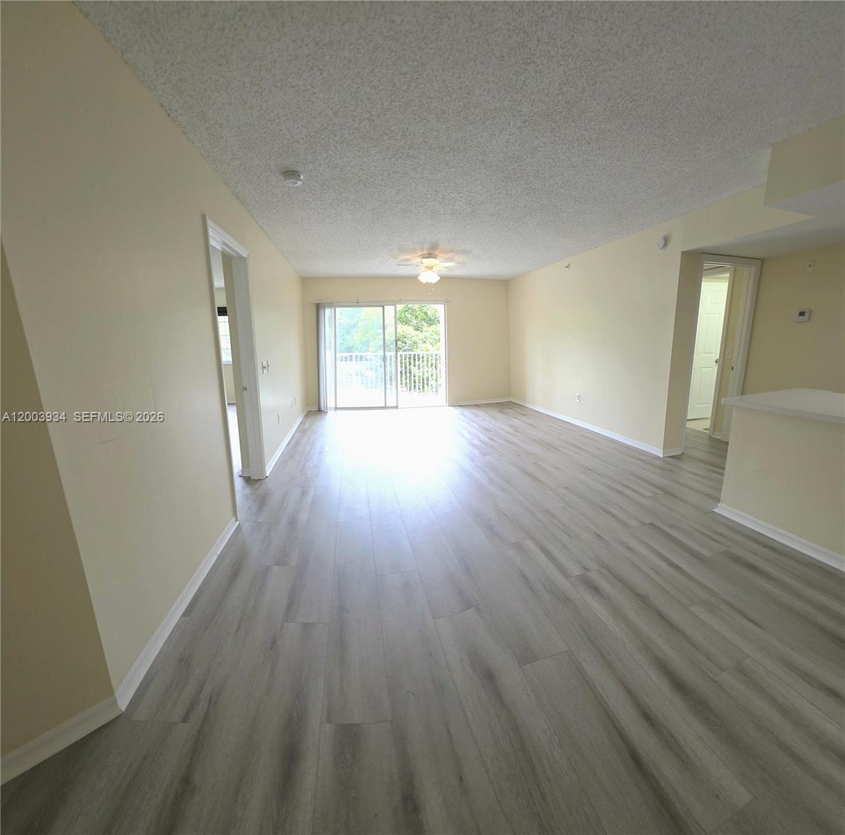 5051 Wiles Road, Unit 201 Coconut Creek, FL 33073 - Photo 10 of 43 an empty room with wooden floor and windows