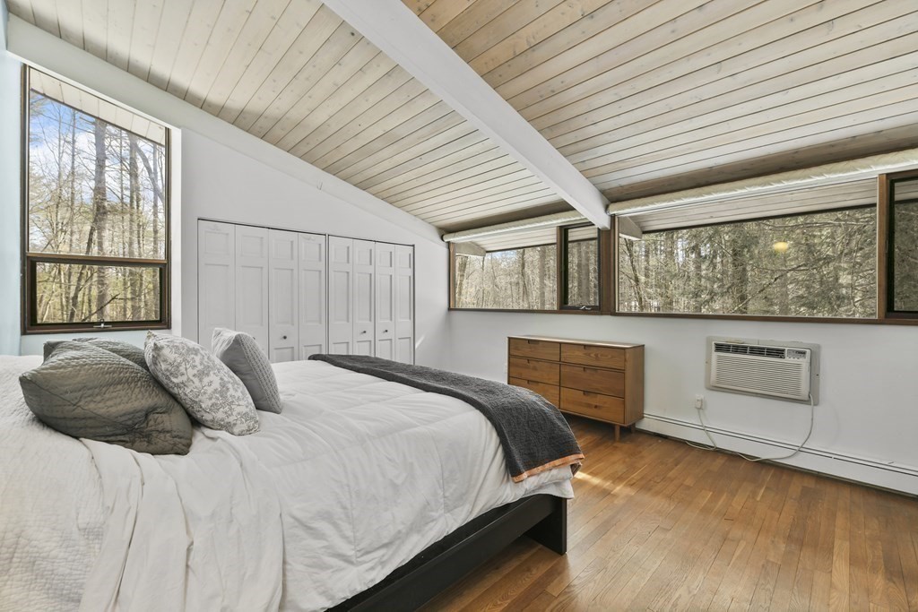 87 Wolf Rock Road Carlisle, MA 01741 - Photo 17 of 28 a bedroom with a bed and wooden floor