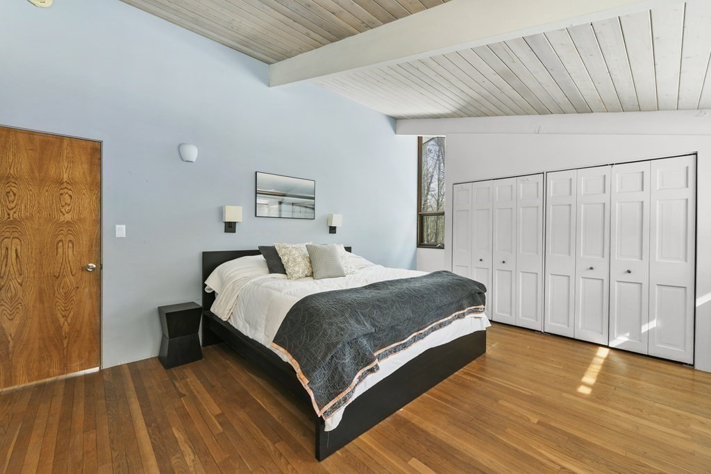 87 Wolf Rock Road Carlisle, MA 01741 - Photo 18 of 28 a spacious bedroom with a bed and wooden floor