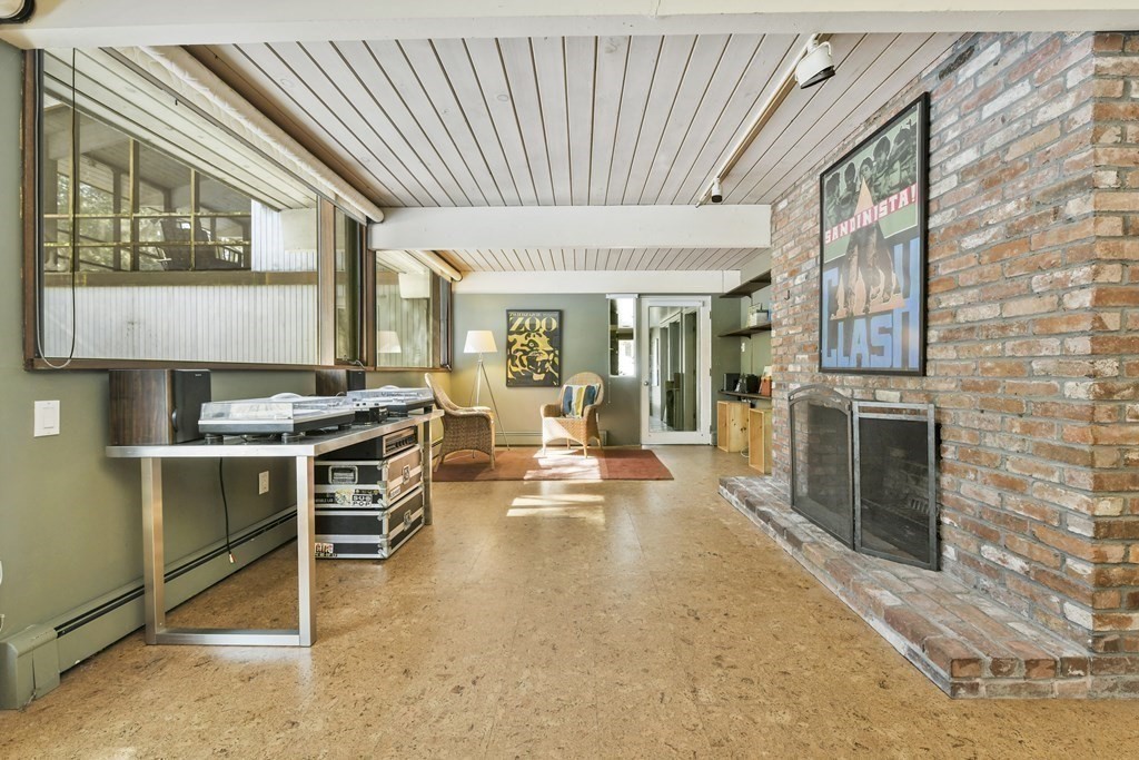 87 Wolf Rock Road Carlisle, MA 01741 - Photo 22 of 28 a living room with furniture a fireplace and large windows