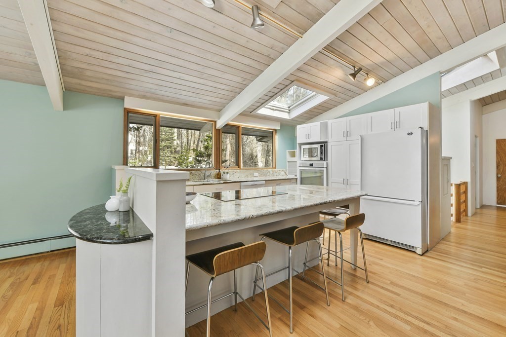 87 Wolf Rock Road Carlisle, MA 01741 - Photo 3 of 28 a kitchen with stainless steel appliances granite countertop a kitchen island hardwood floor and a table