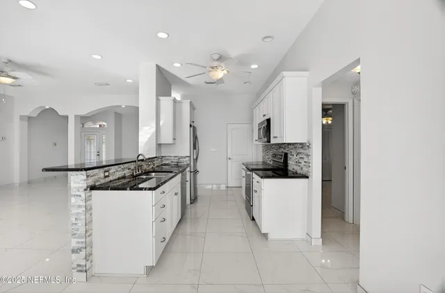 an empty room with windows and ceiling fan