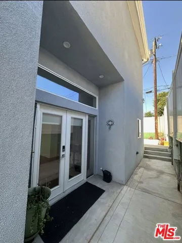 a living room with stainless steel appliances furniture a rug and a kitchen view