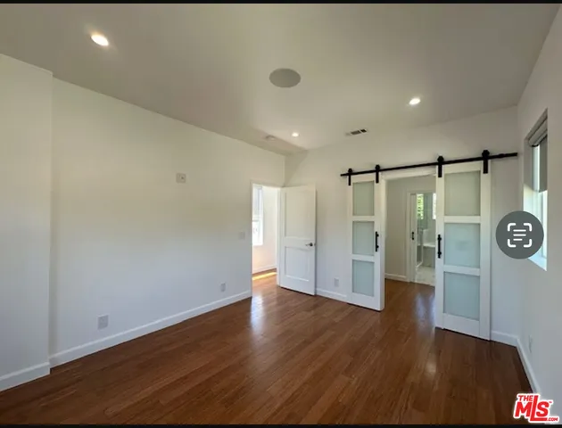 a living room with stainless steel appliances kitchen island hardwood floor and a view of kitchen