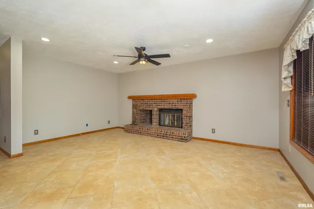 a view of an empty room with glass door and windows