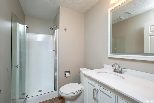 an empty room with wooden floor closet and windows