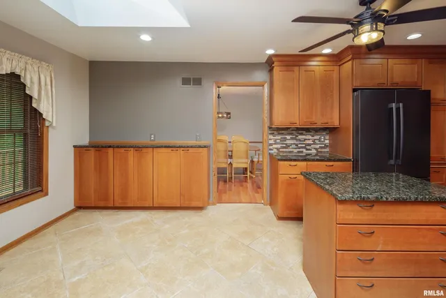 a kitchen with granite countertop a refrigerator and a stove top oven