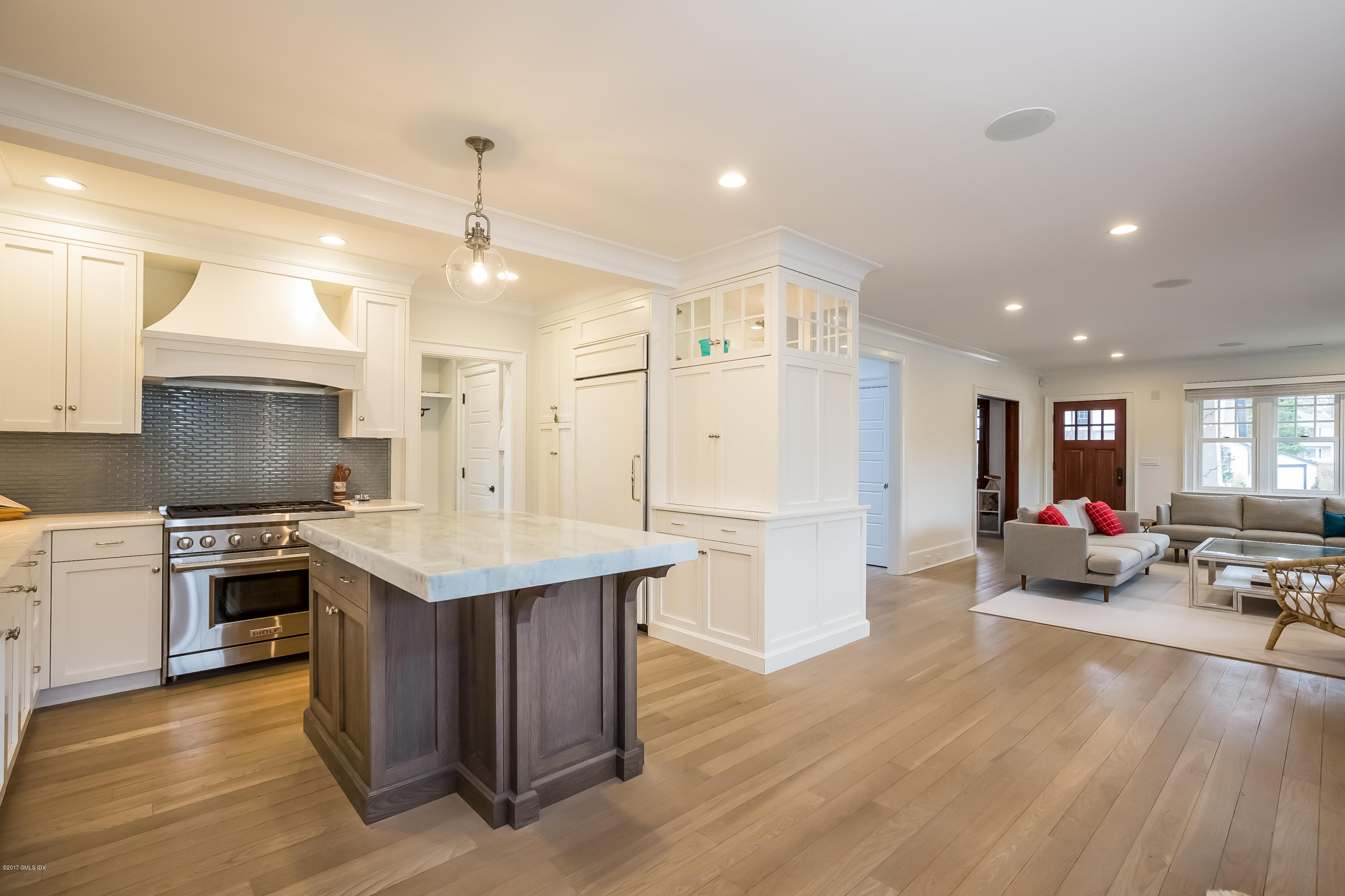 39 Edgewater Drive Old Greenwich, CT 06870 - Photo 6 of 19 a kitchen with a sink a refrigerator a stove top oven a dining table and chairs with wooden floor