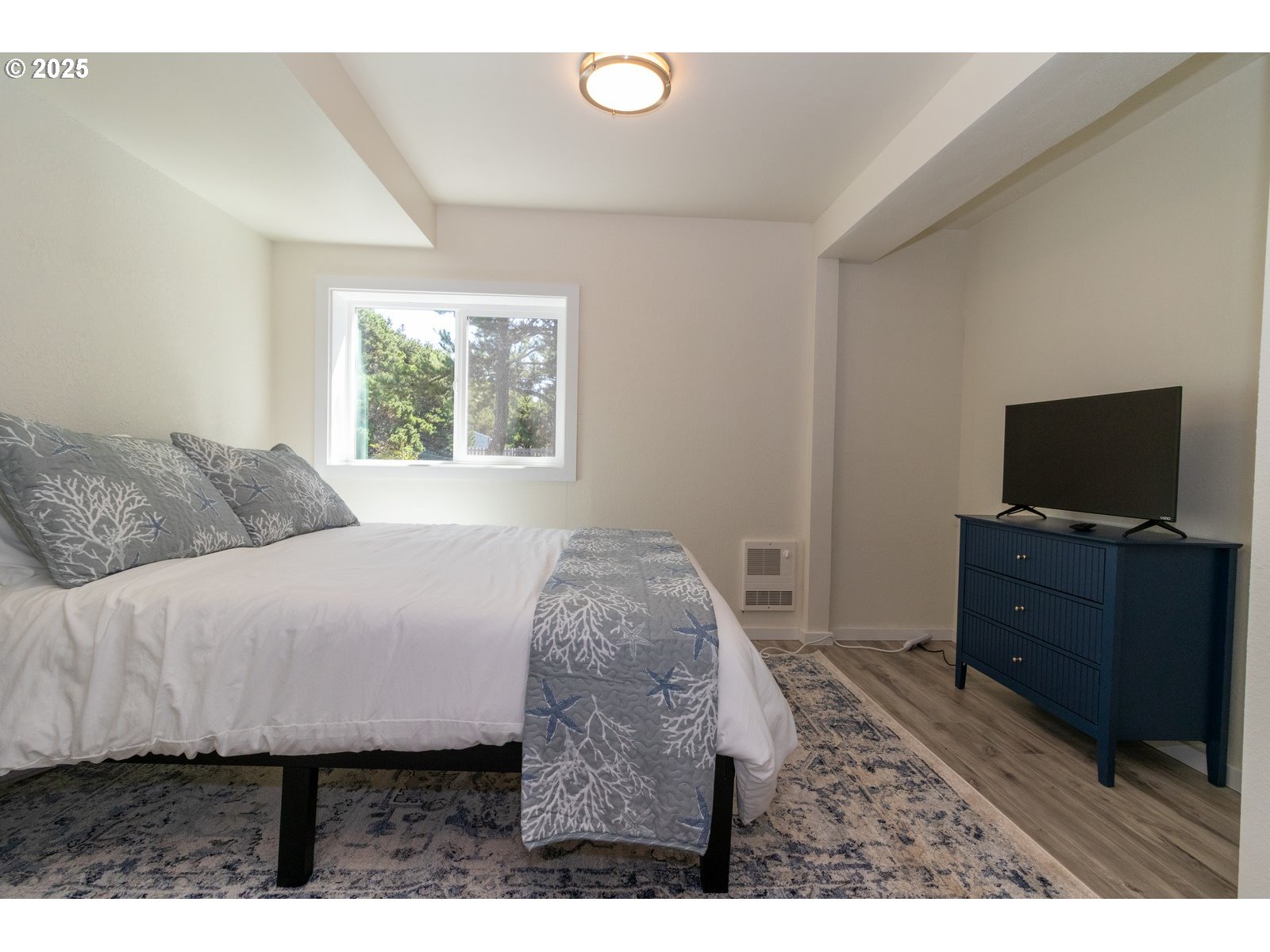 4589 Meares Street Florence, OR 97439 - Photo 28 of 35 a bedroom with a bed and a flat screen tv