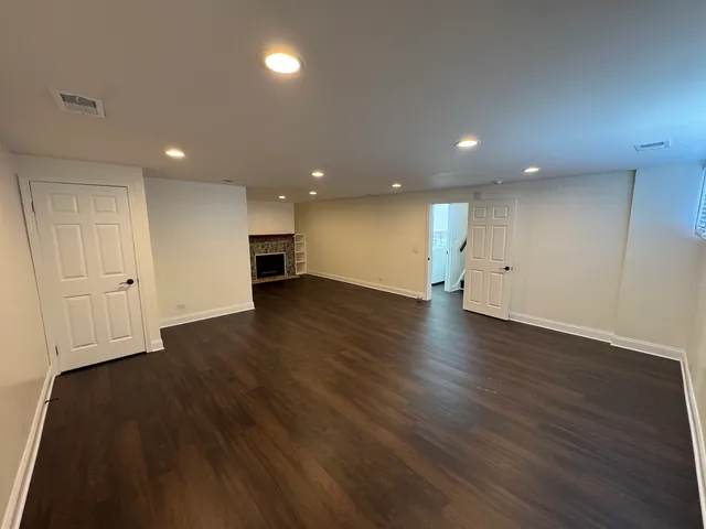 an empty room with wooden floor and fireplace