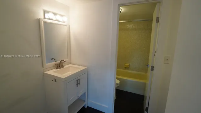 a bathroom with a sink a toilet and mirror