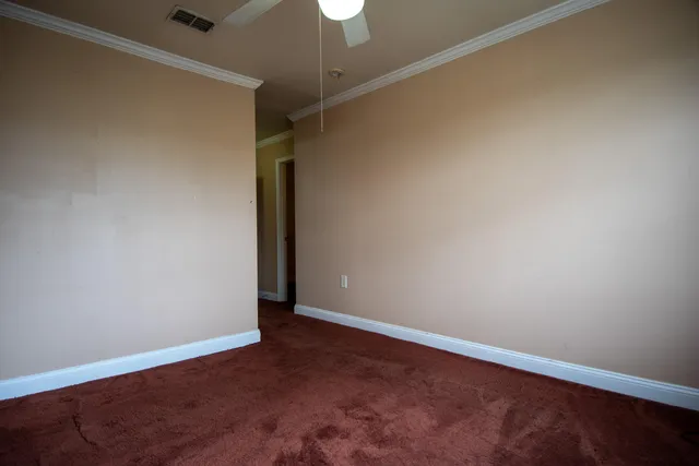 an empty room with a ceiling fan and wooden floor