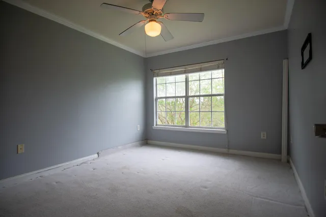 an empty room with a window and a fan